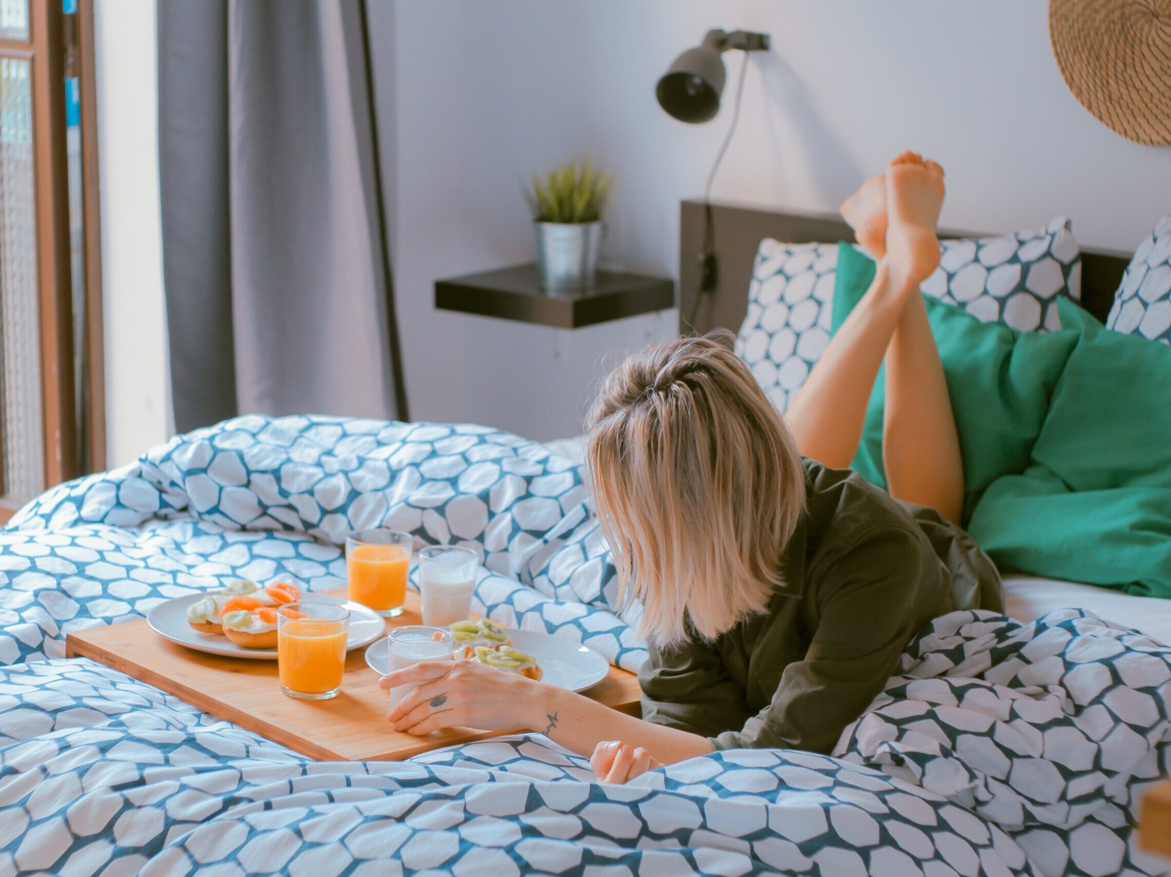 woman lying on bed white holding board