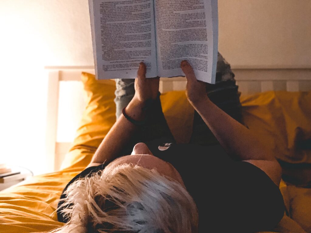 person reading book on bed