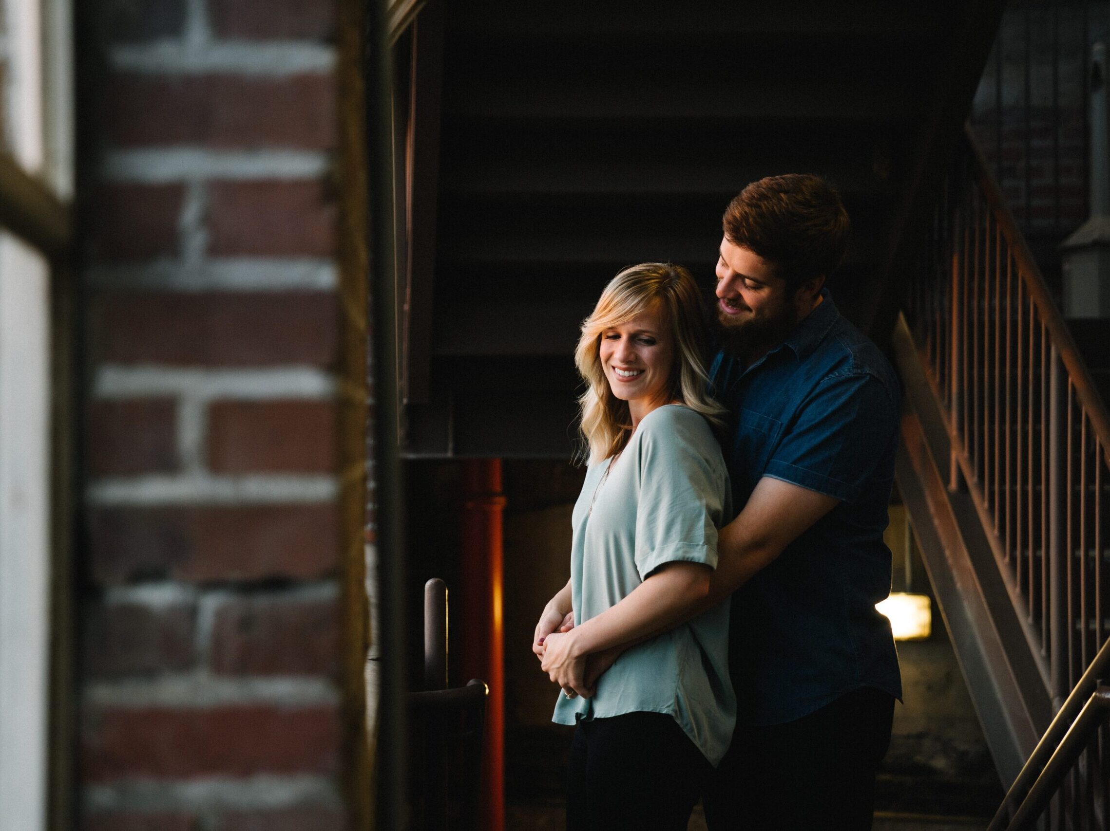 man hugging woman from behind near stair