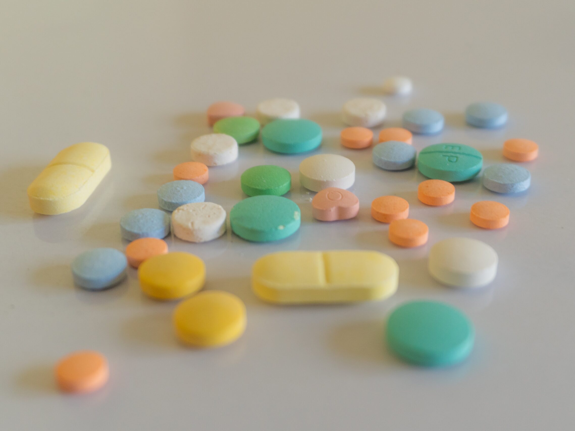 white yellow and teal medication pill