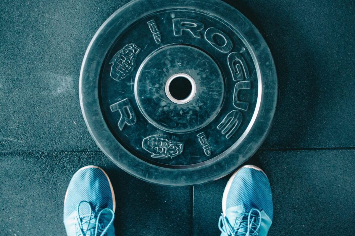 person standing beside black weights