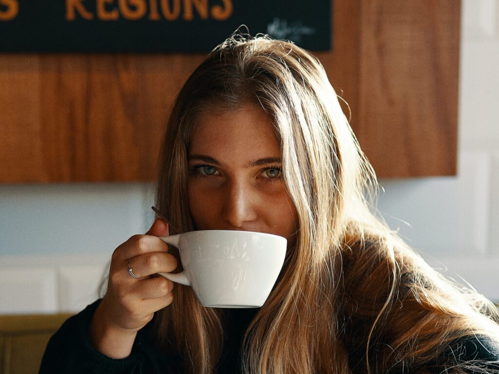 woman holding white ceramic teacup