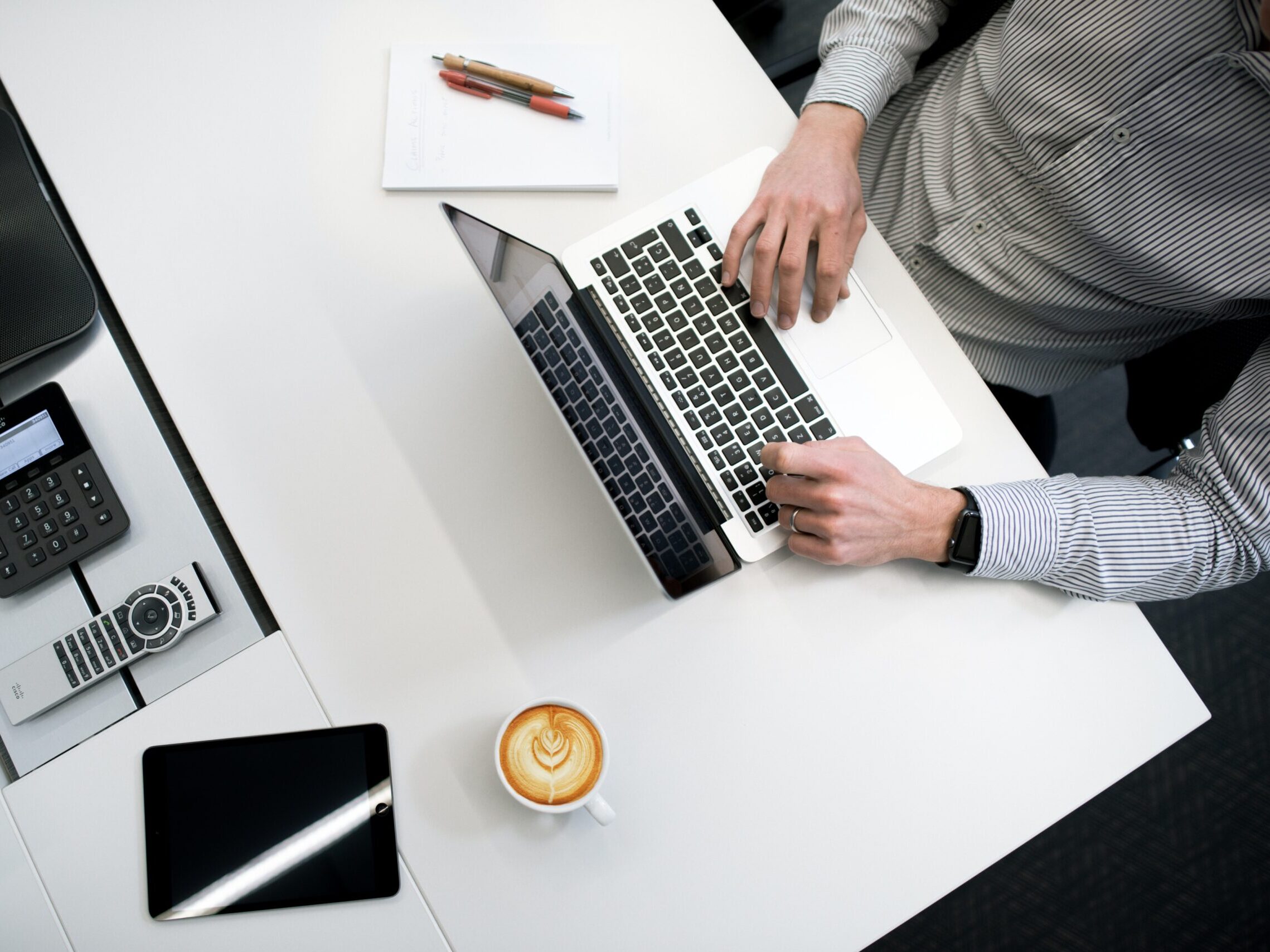 person using laptop on white wooden table