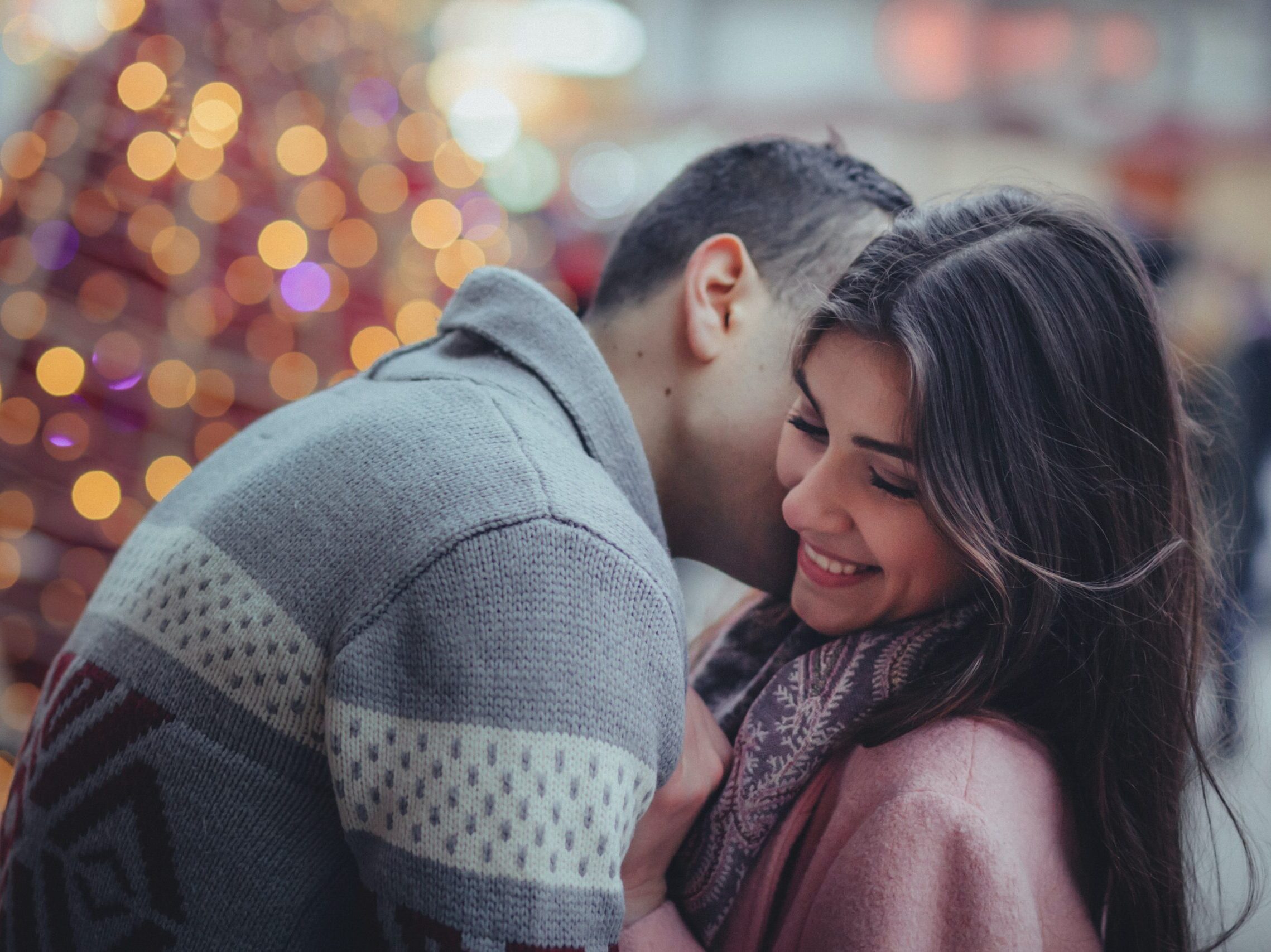 shallow photography of man hugging woman outdoors