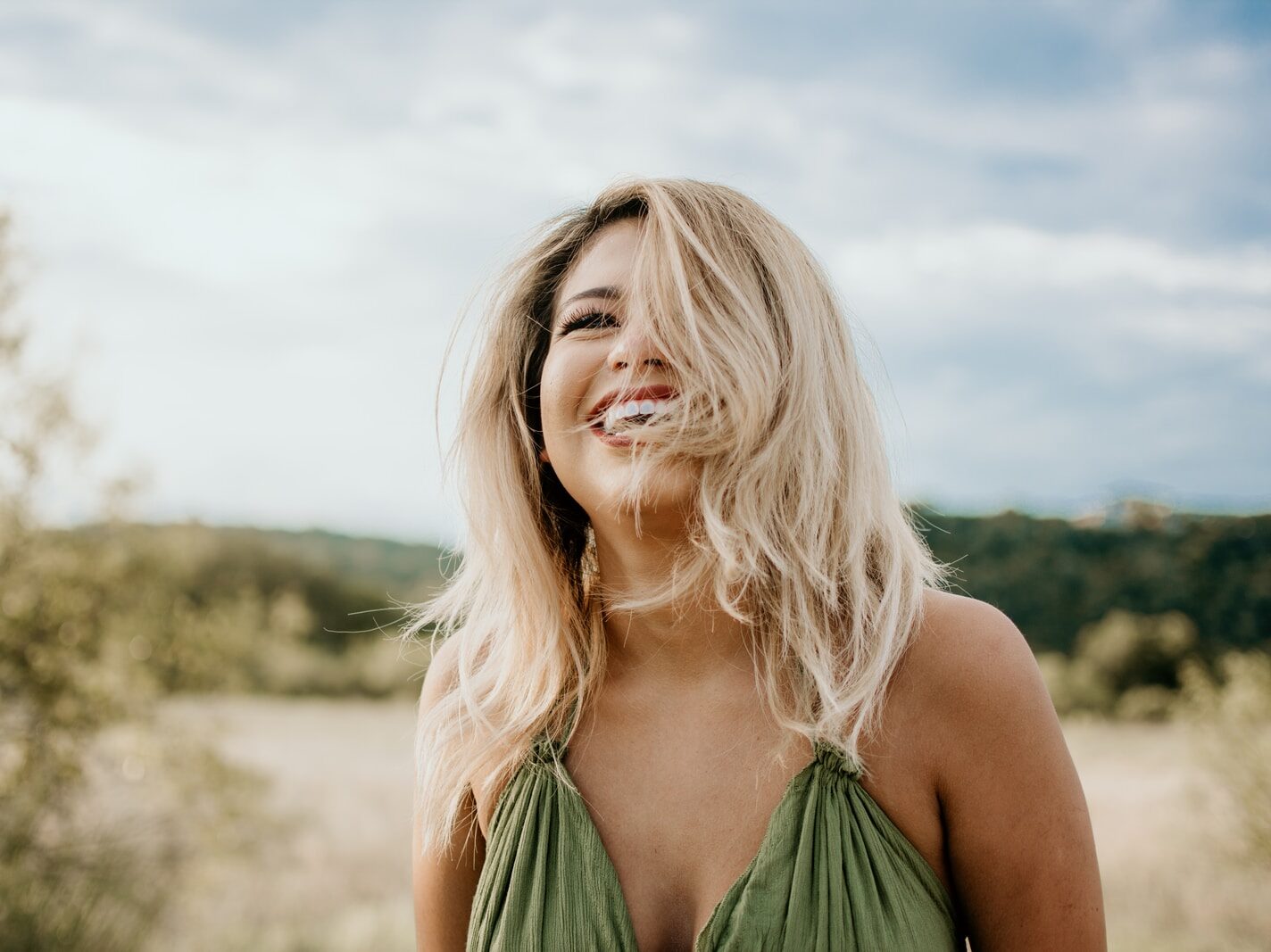 time-lapse photography of laughing woman with hair covering half of her face