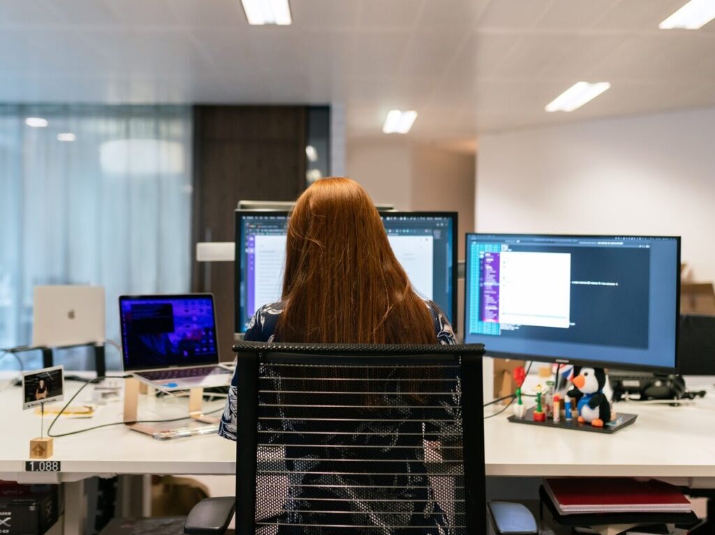 woman in black shirt sitting on chair in front of computer