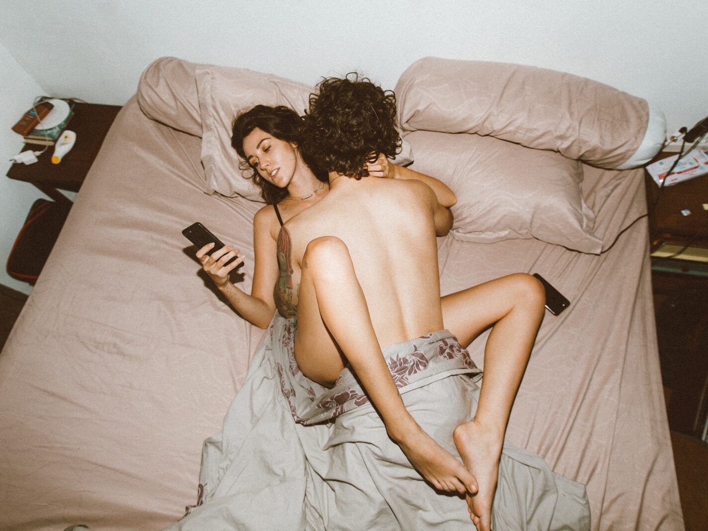 Couple having sex and using smartphone