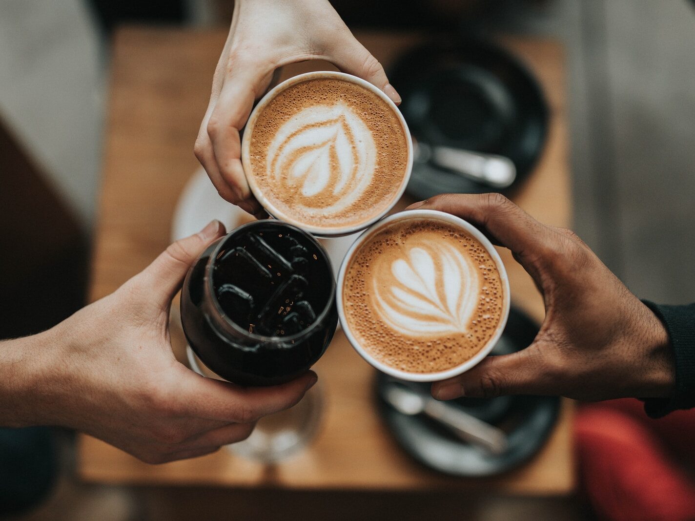 three person holding beverage cups