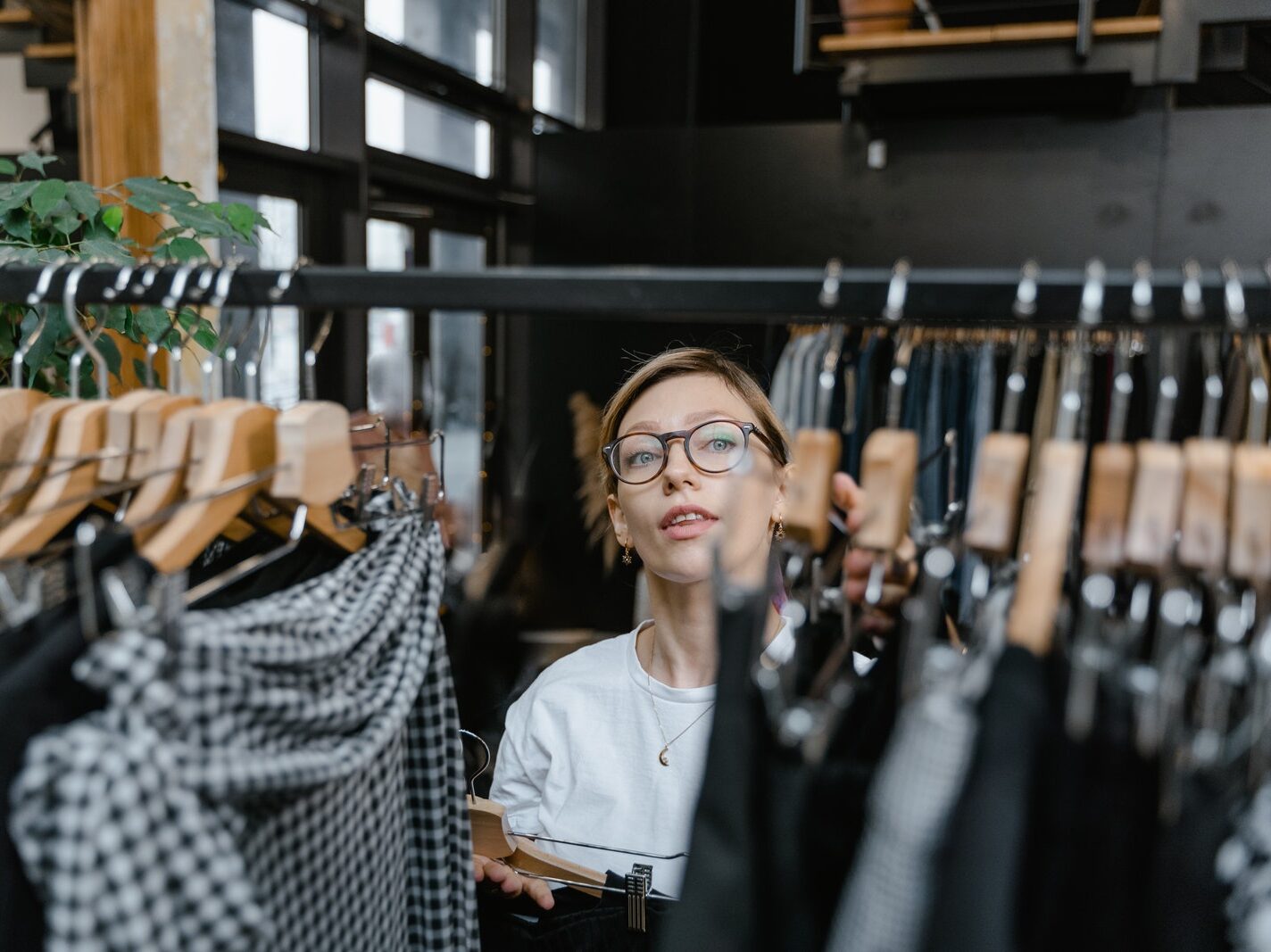 Woman Adding More Clothes on the Clothes Rack