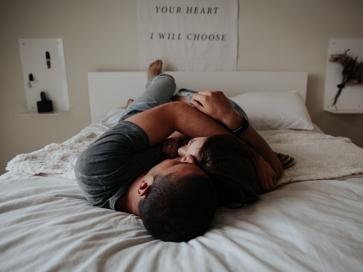 A man and woman cuddling together in bed.