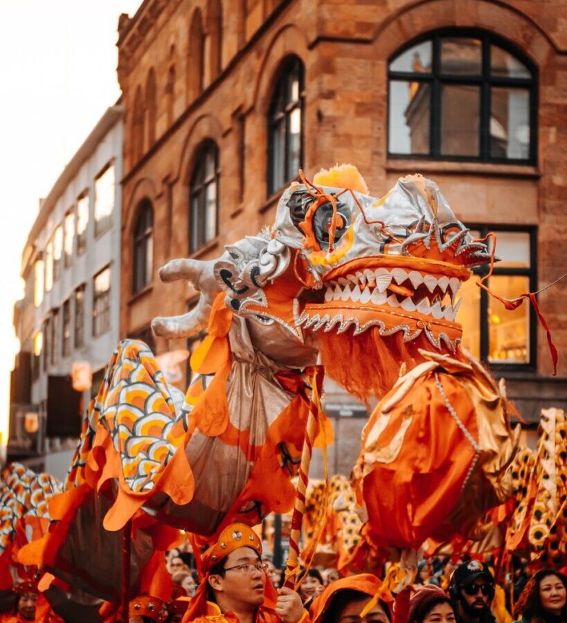 people in orange and white costume walking on street during daytime