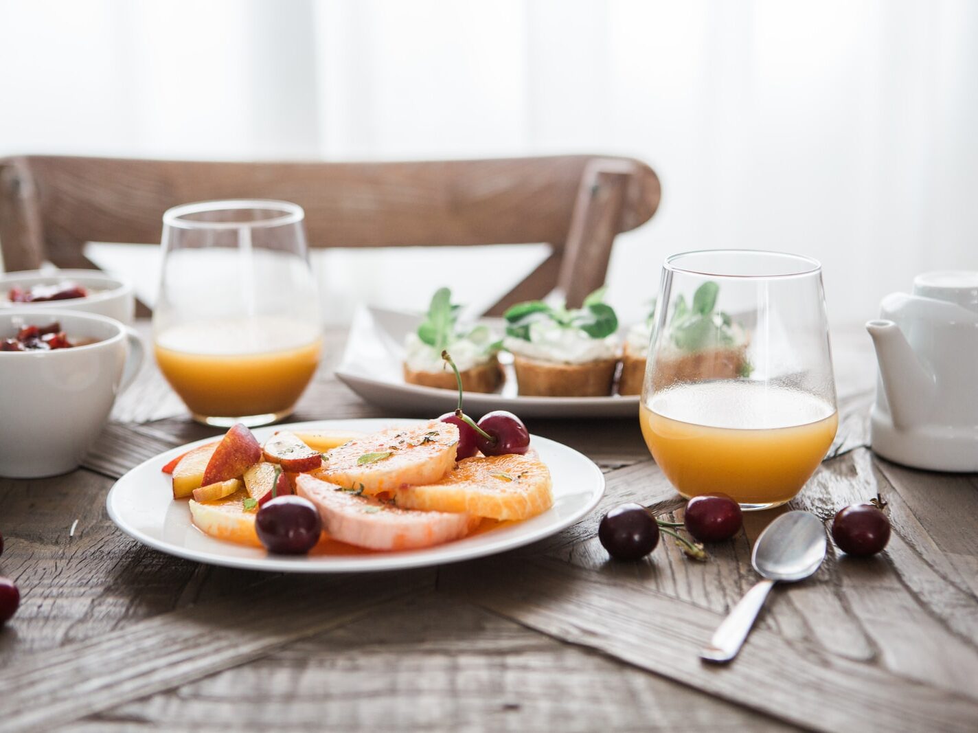 slice fruits on plate on near glass cups