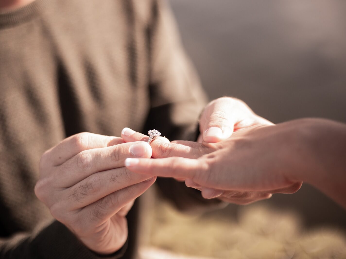 person holding silver diamond ring