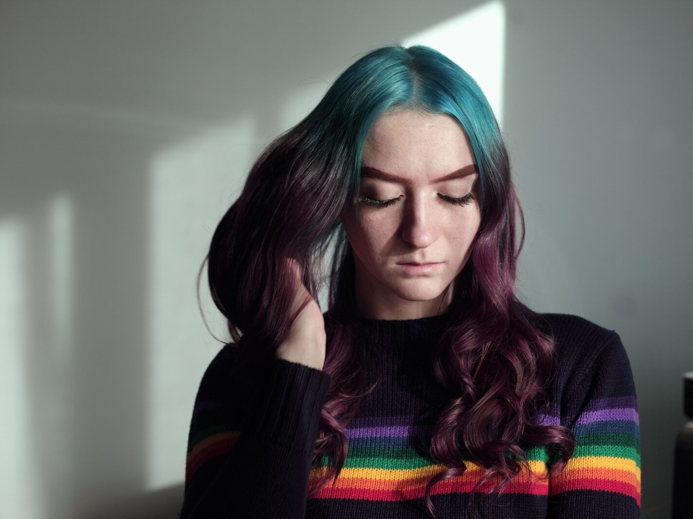 woman holding her hair in white wall paint room