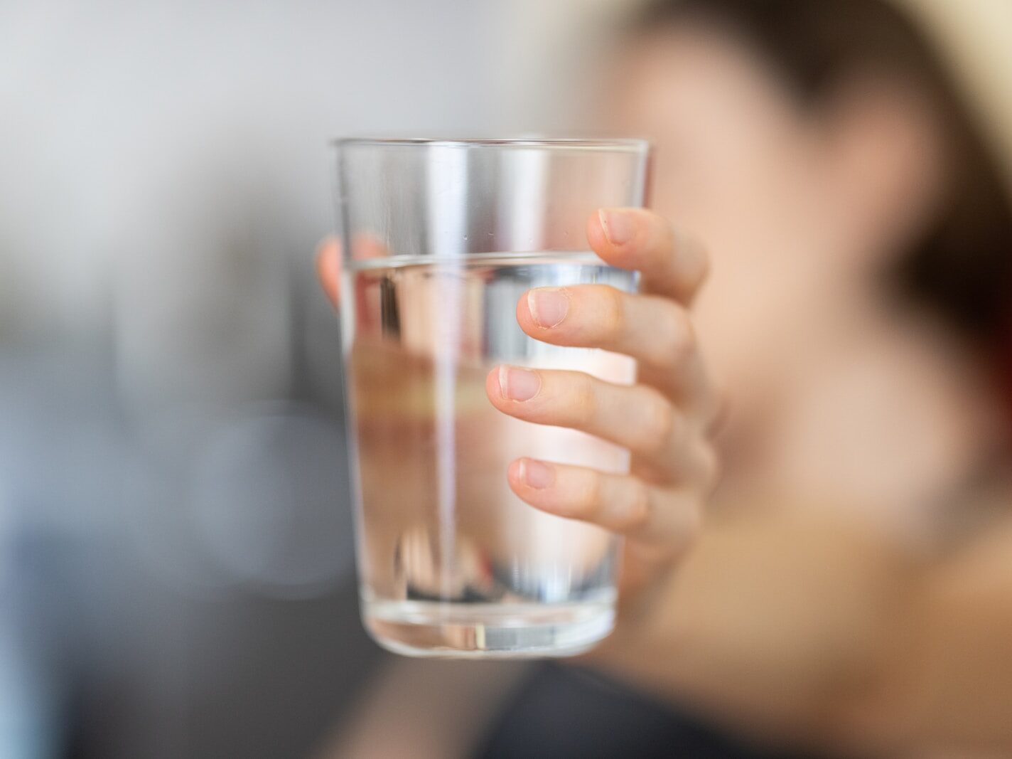 person holding clear drinking glass