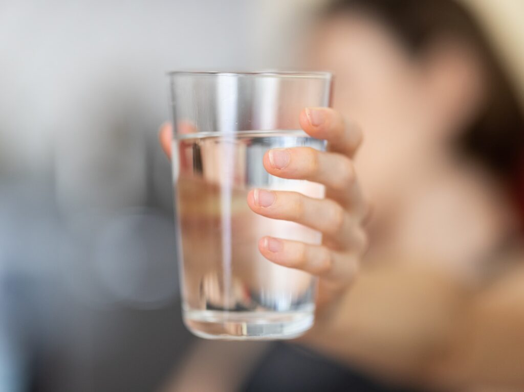 person holding clear drinking glass
