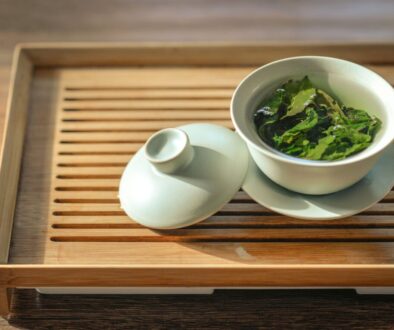 green tea leaves in white ceramic bowl with open lid