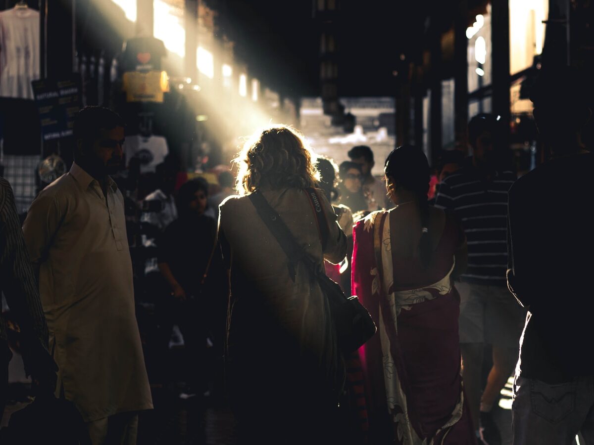 people waking between brown wooden stands during daytime