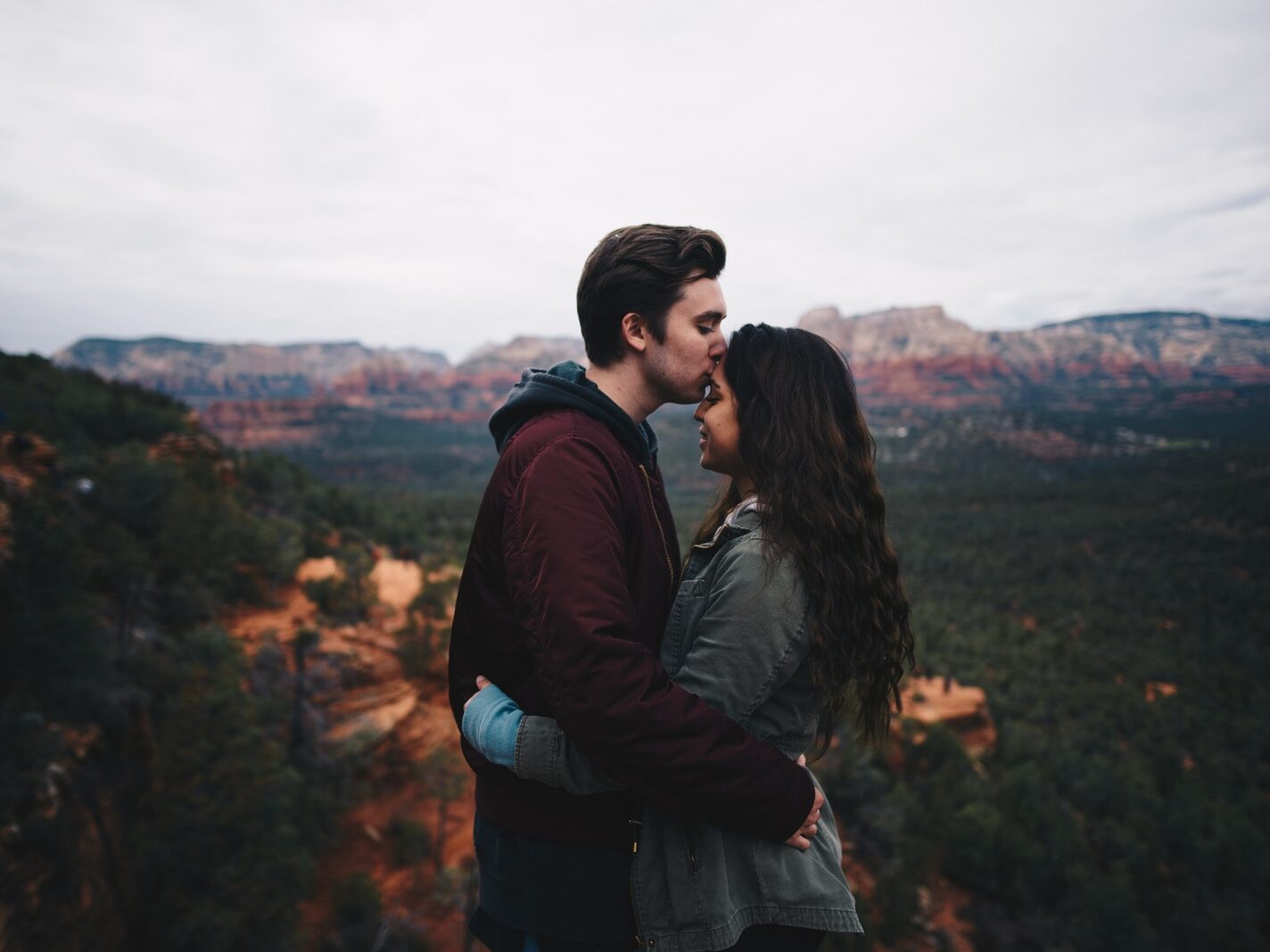 man kissing woman's forehead