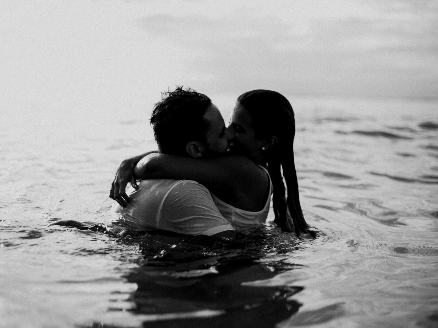 Man and Woman Kissing Together on Body of Water