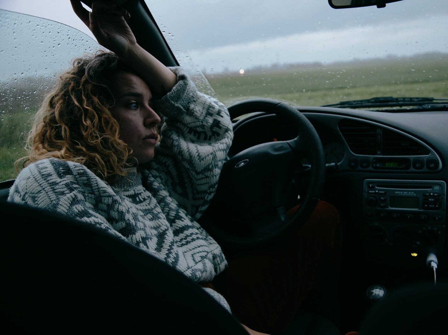 woman in black and white scarf driving car