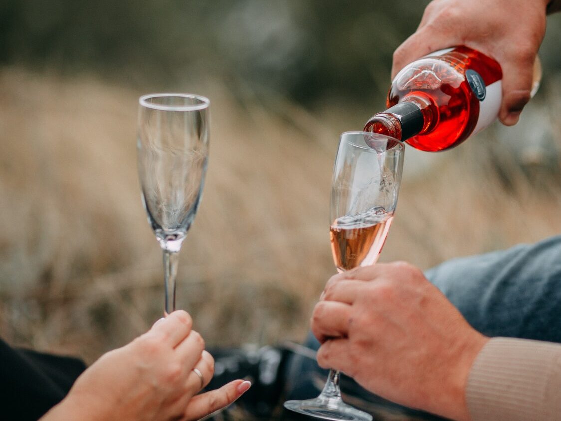 Person Pouring Champagne in Champagne Flute