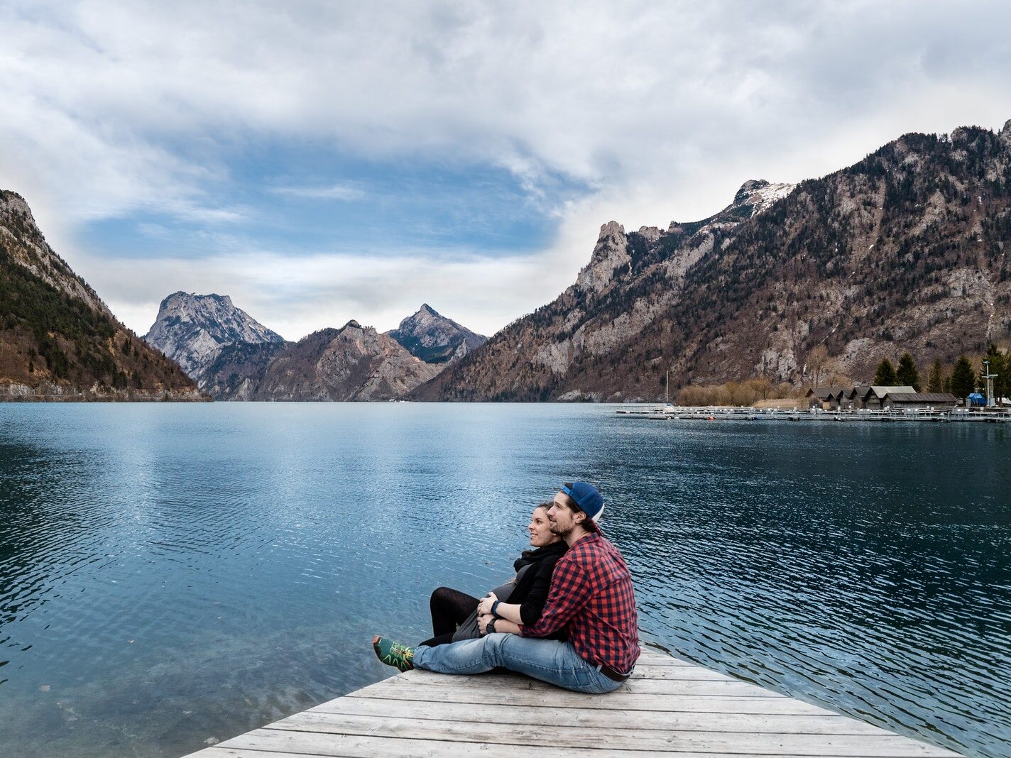 Man and Woman Sitting on Brown Wooden Dock