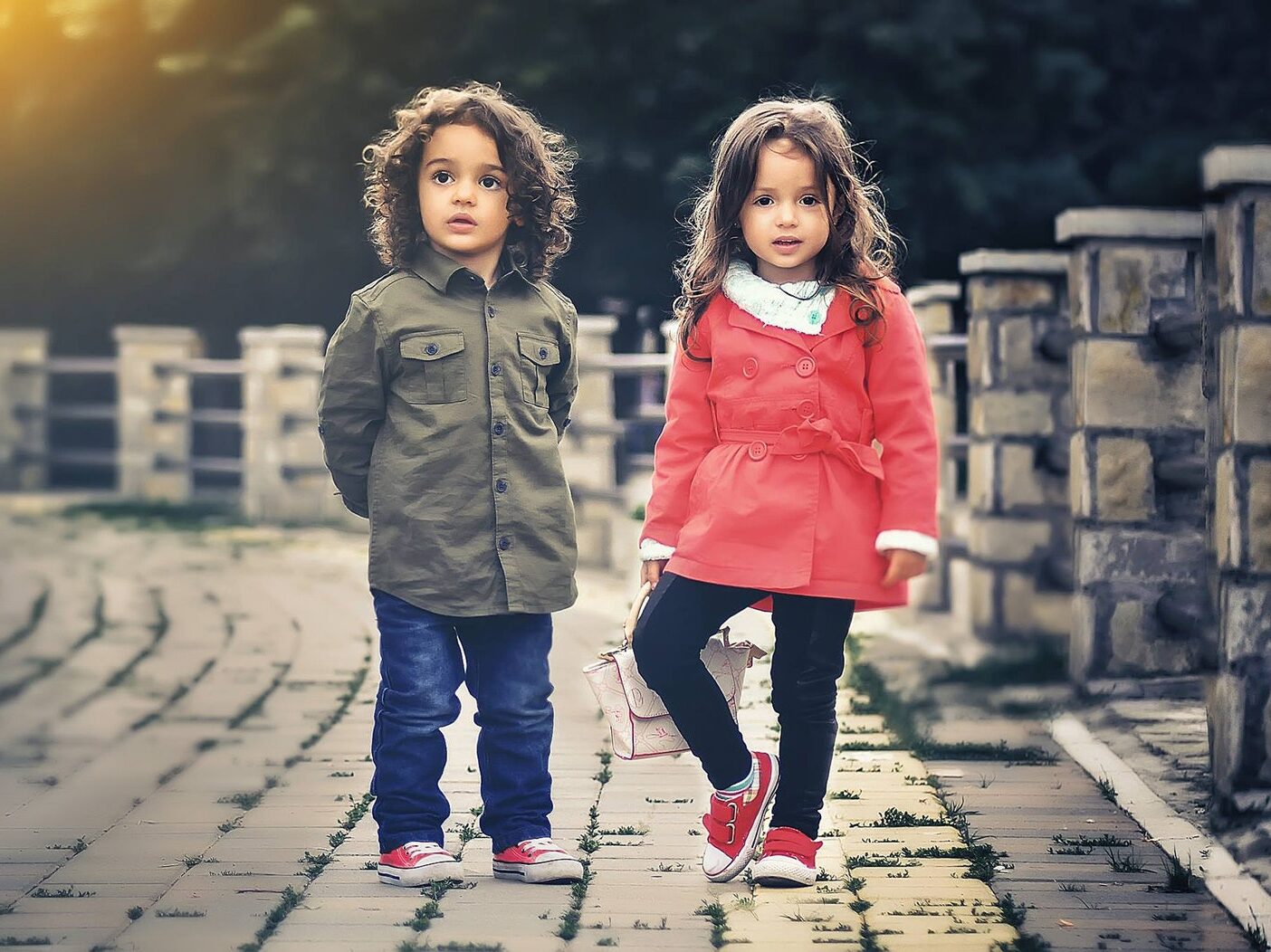 Two Children Standing Near Concrete Fence