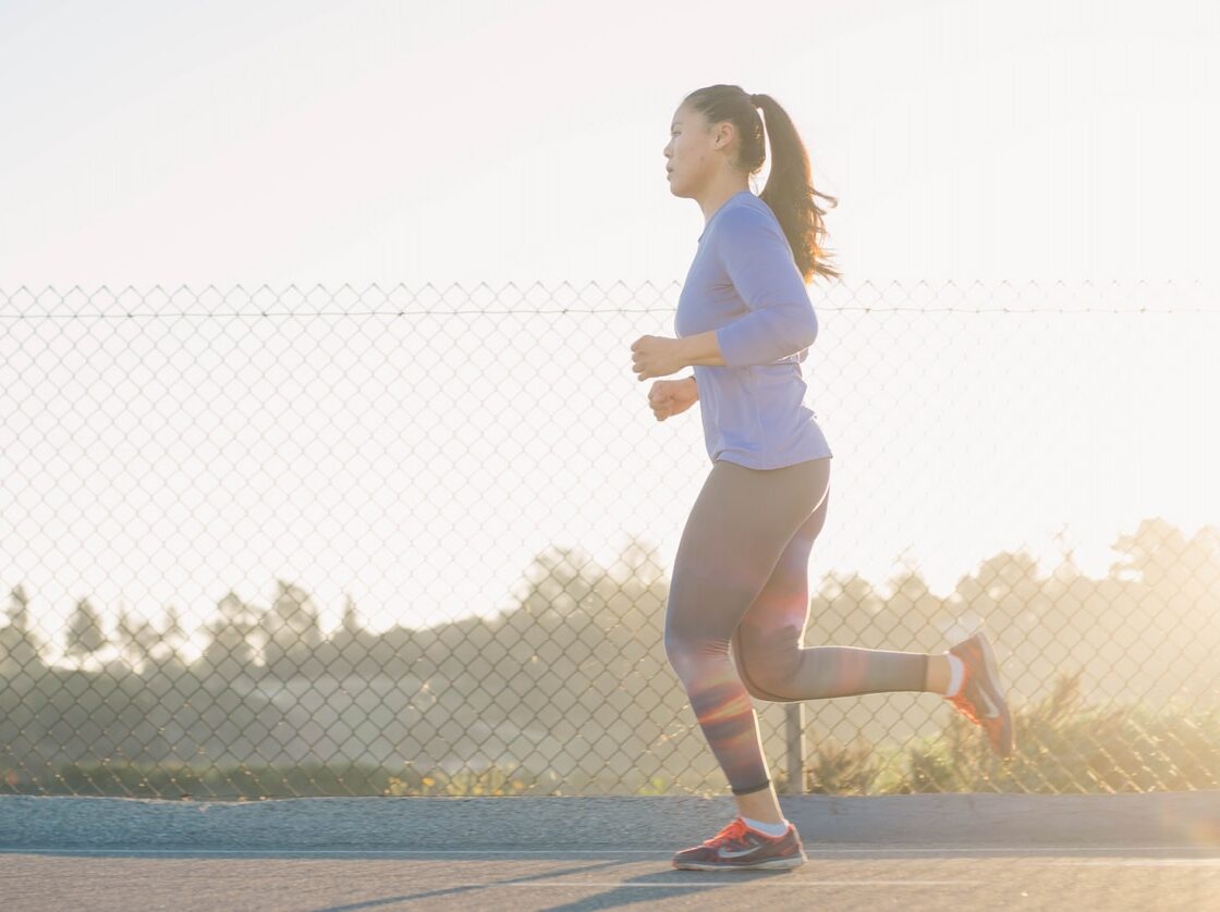 woman jogging near wire fence