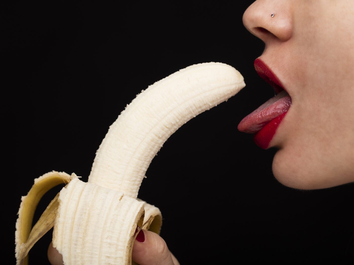 Person Holding Banana With Tongue Out
