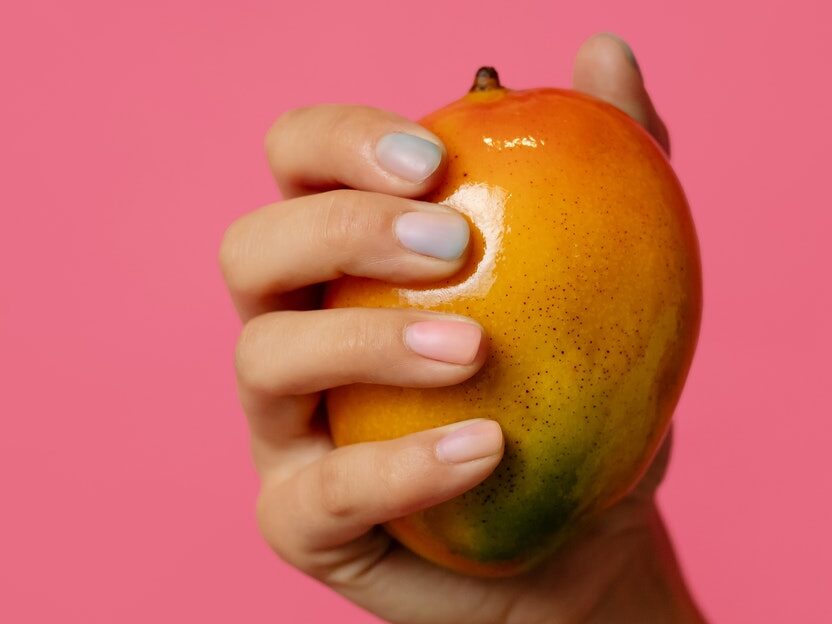 Person Holding Ripe Mango Fruit