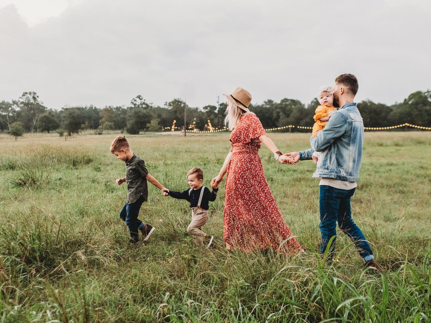 woman holding man and toddler hands during daytime