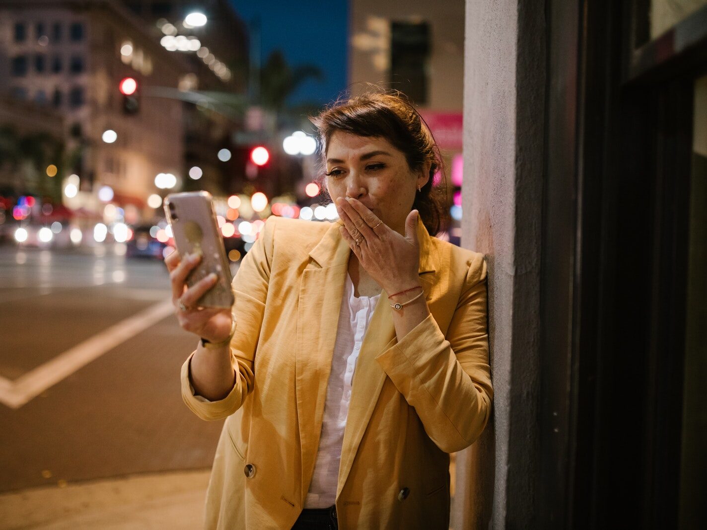 Woman in Brown Coat Holding White Smartphone