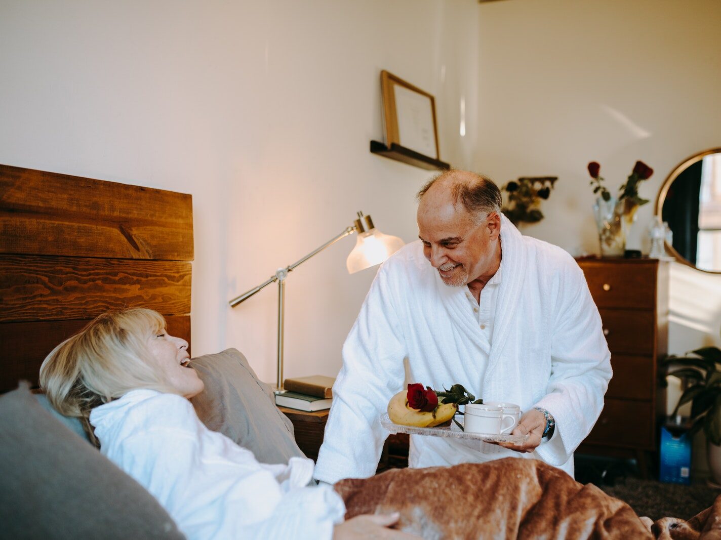 Photograph of a Man Giving Breakfast to a Woman on the Bed
