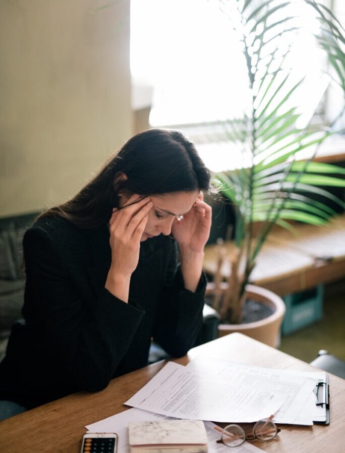 A Woman at Work Massaging her Head