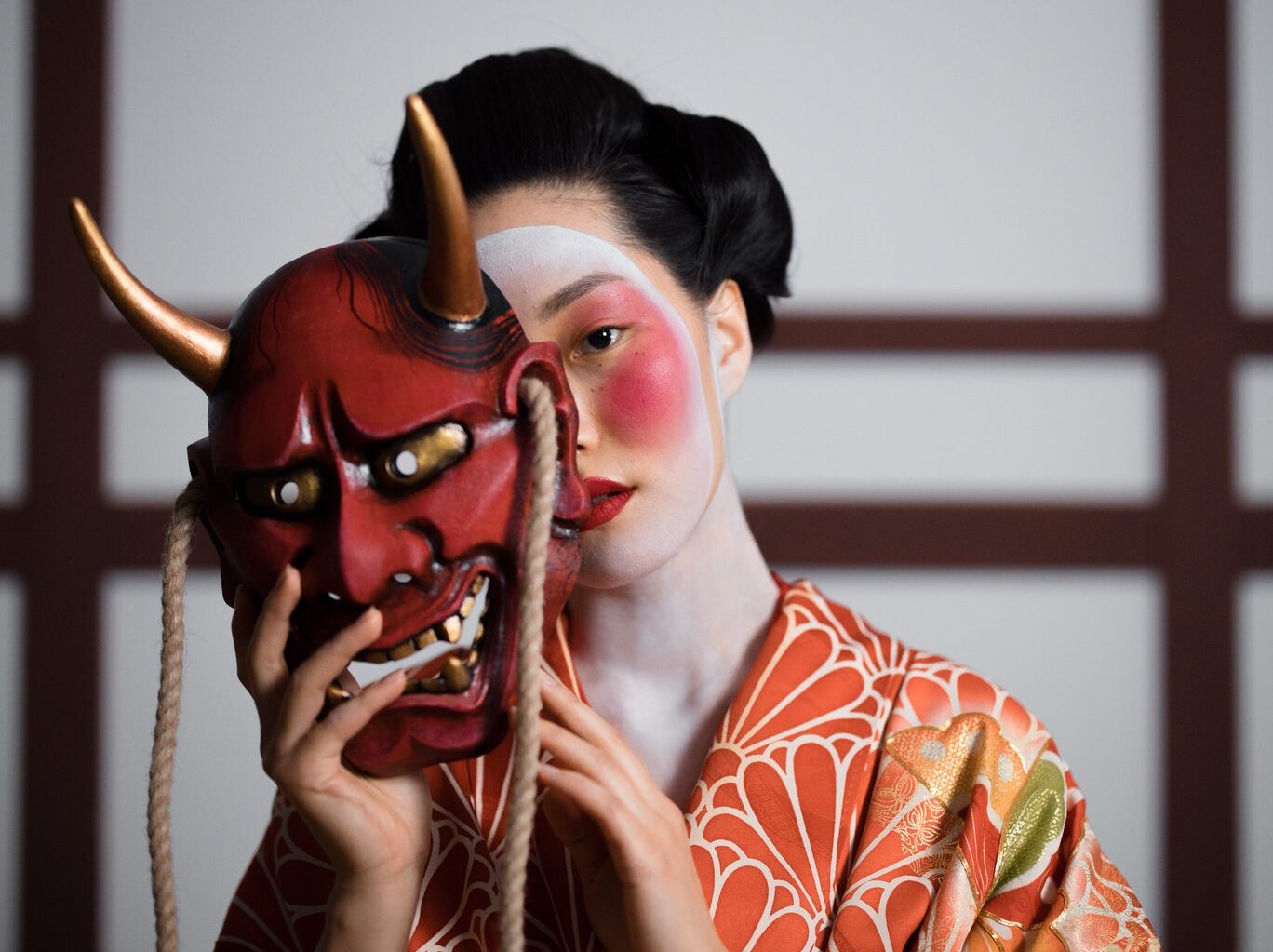 Woman in Red and White Floral Hijab Holding Brown Wooden Stick