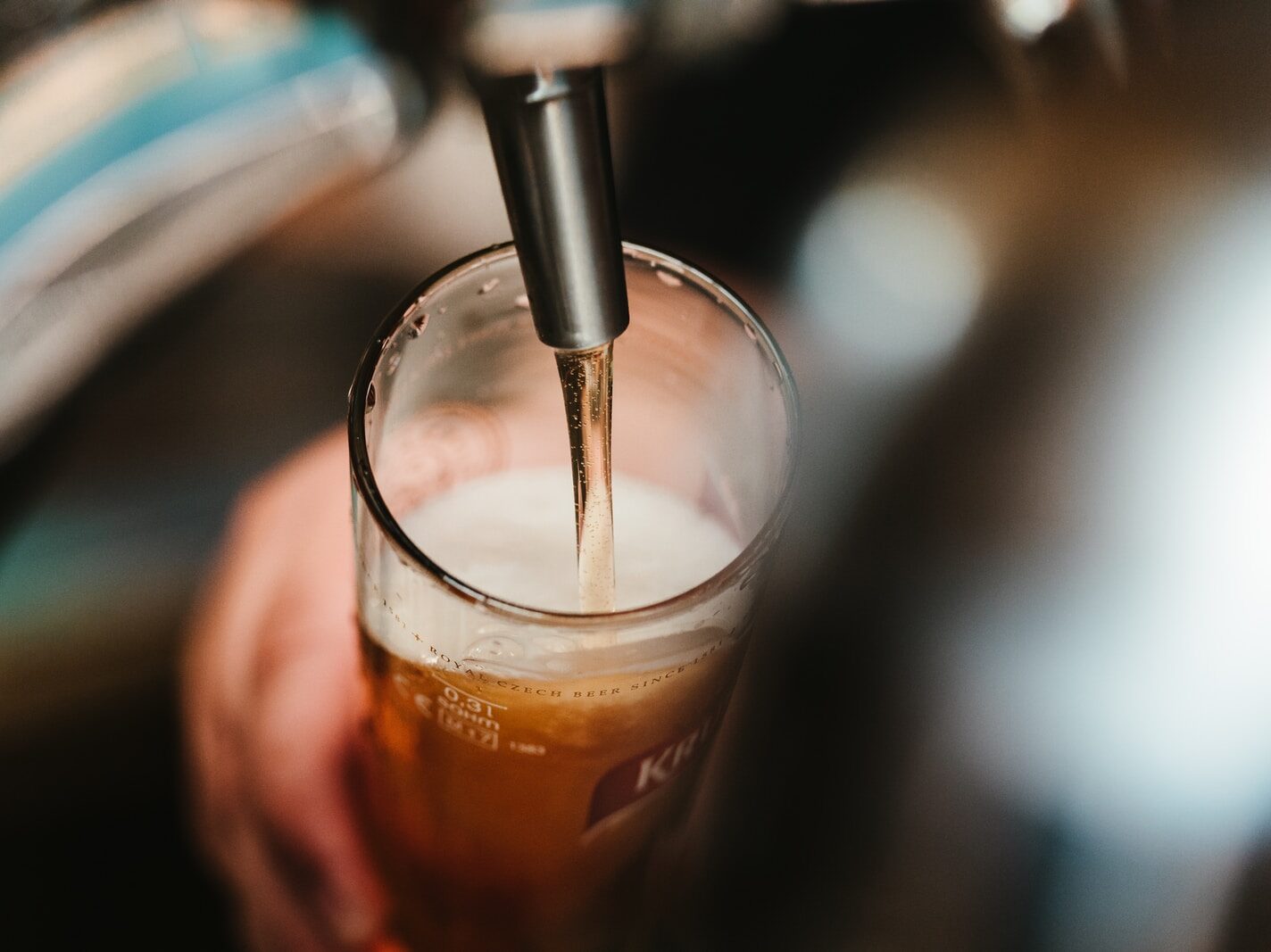 person filling clear glass with liquid