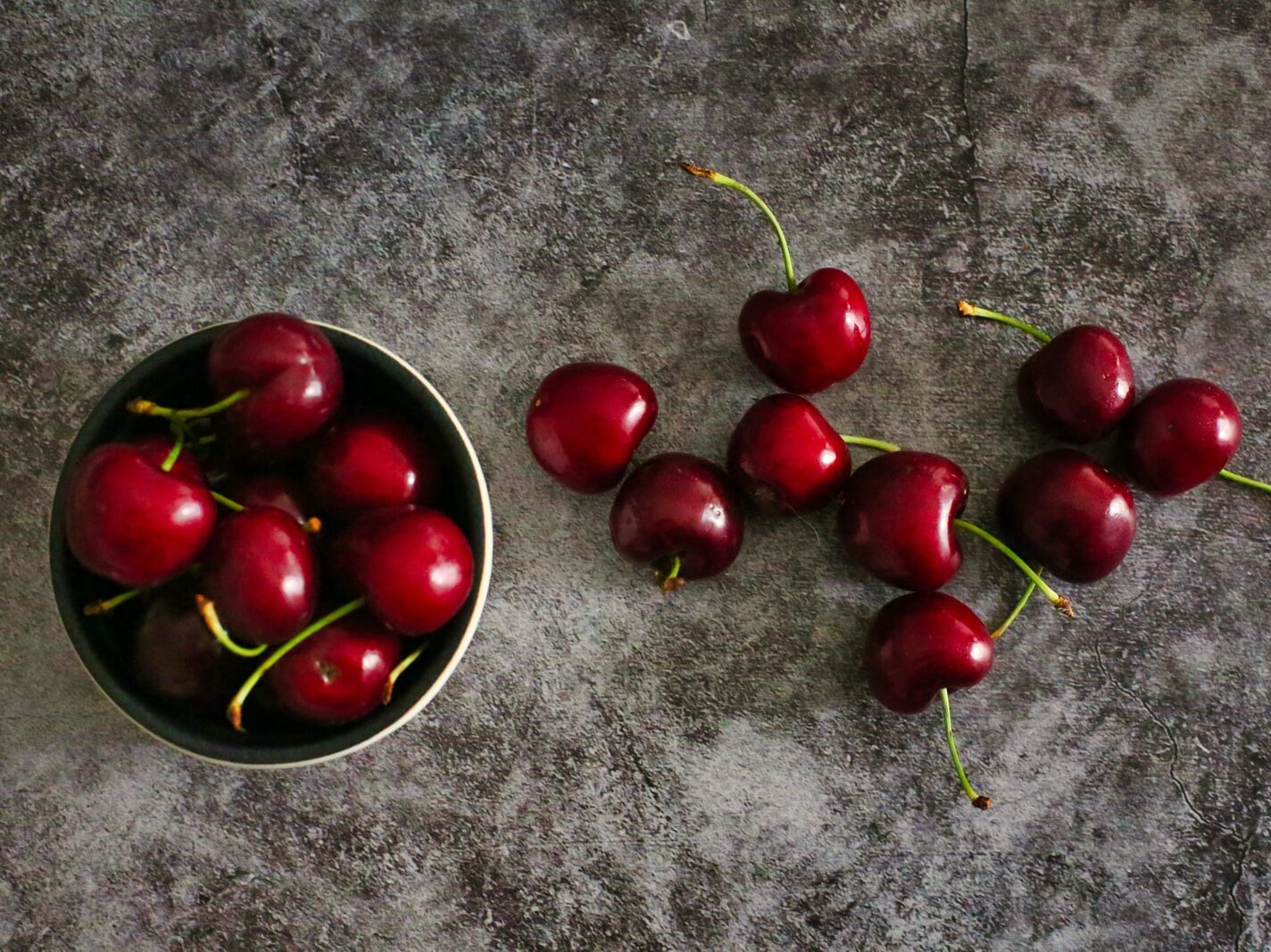red cherries on black round plate