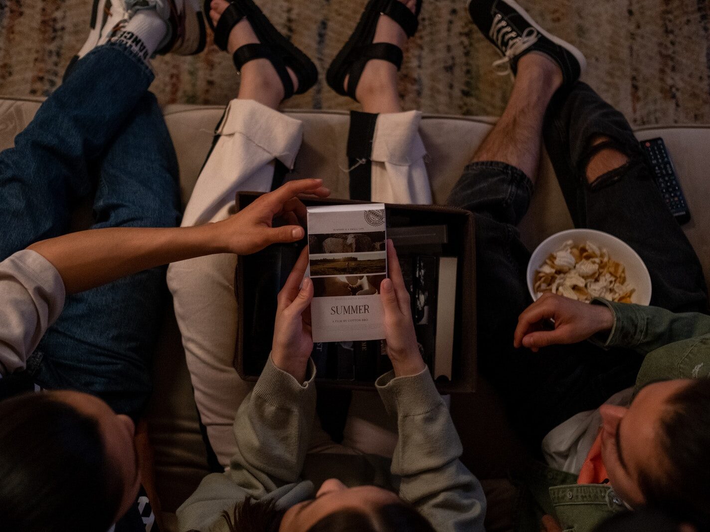 Directly above three friends choosing movie to watch