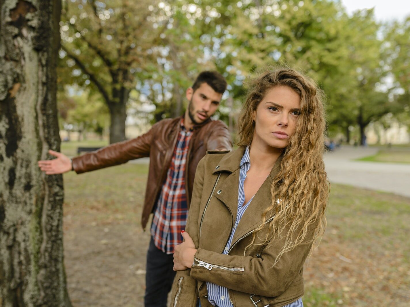 Woman And Man Wearing Brown Jackets Standing Near Tree