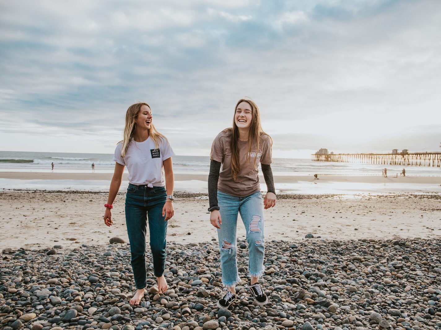 two women walking on pebbles