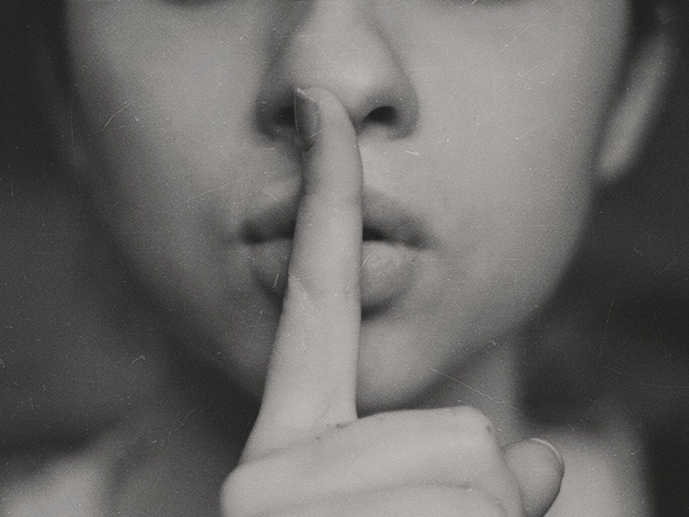 grayscale photo of woman doing silent hand sign