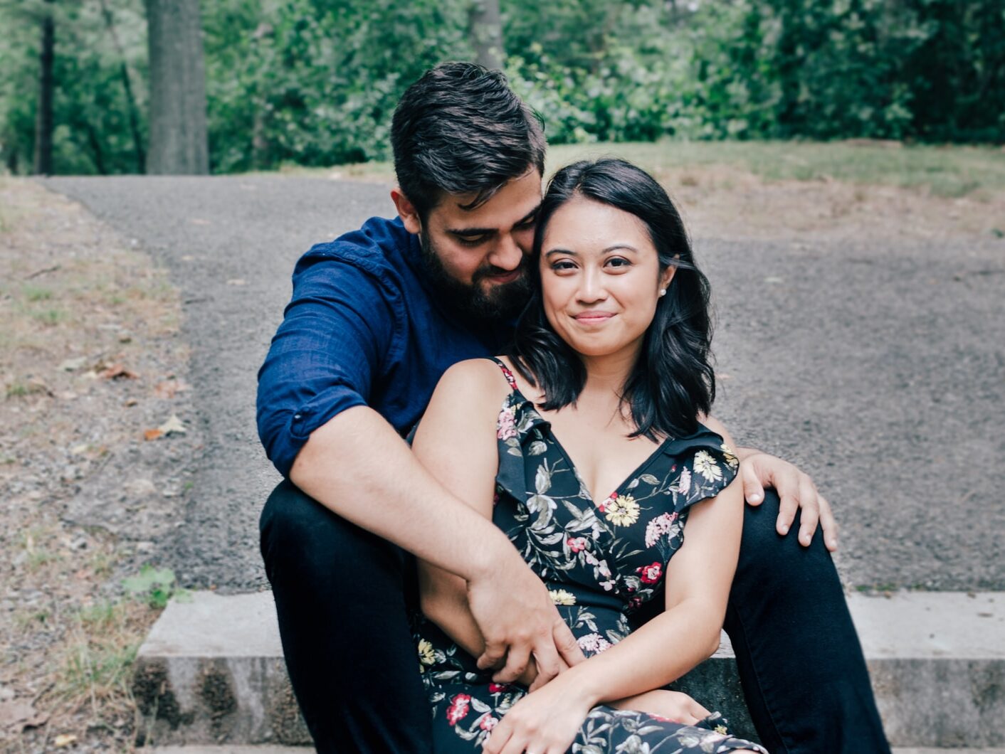 man wearing blue dress shirt and black pants and woman in black floral dress