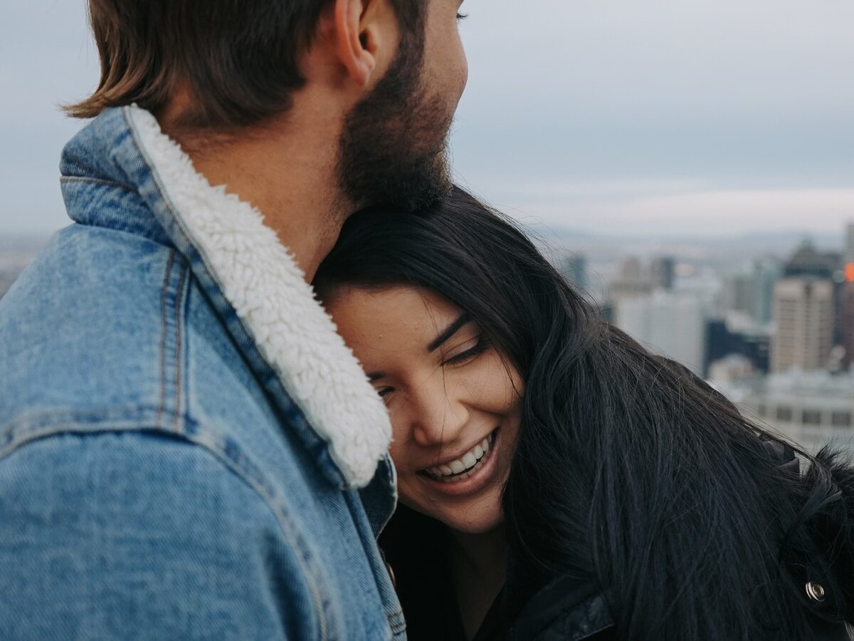 man and woman cuddling on rooftop