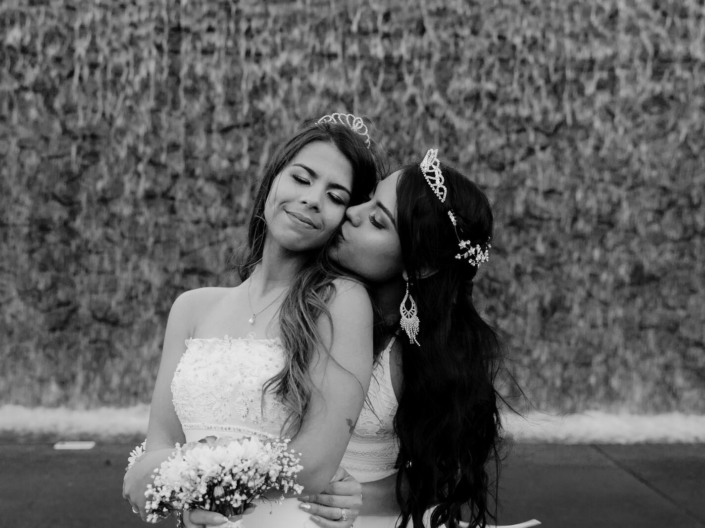 grayscale photo of woman in wedding dress beside woman in wedding dress