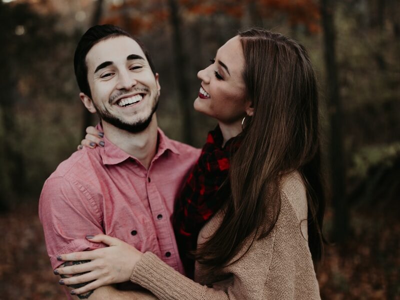 woman hugging man selective focus photography