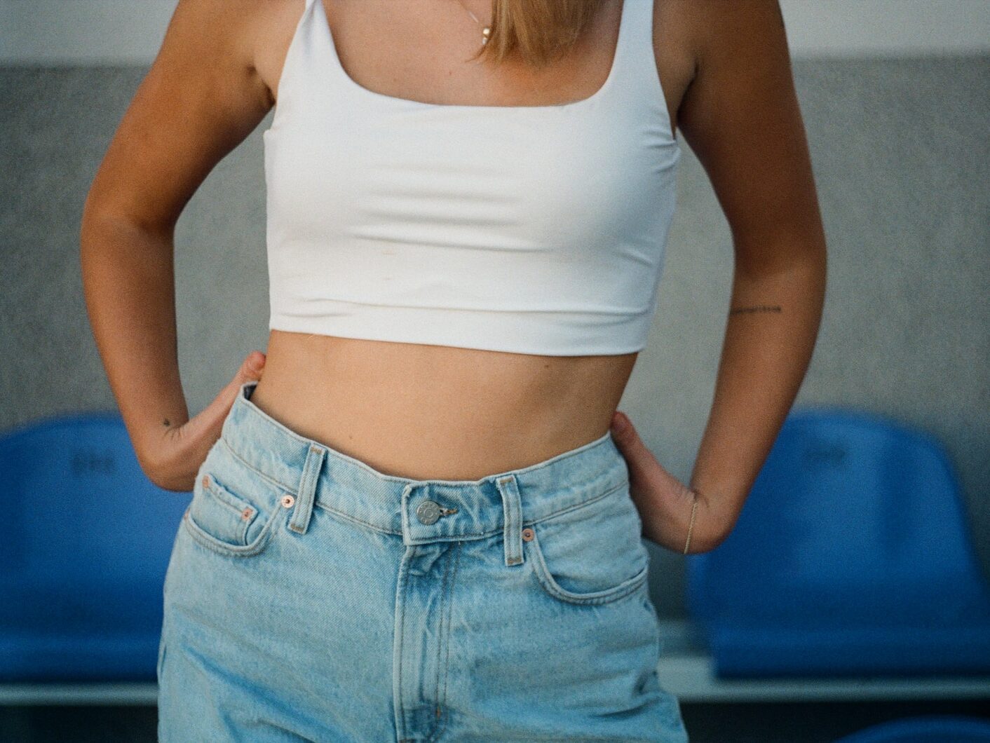 woman in white tank top and blue denim jeans