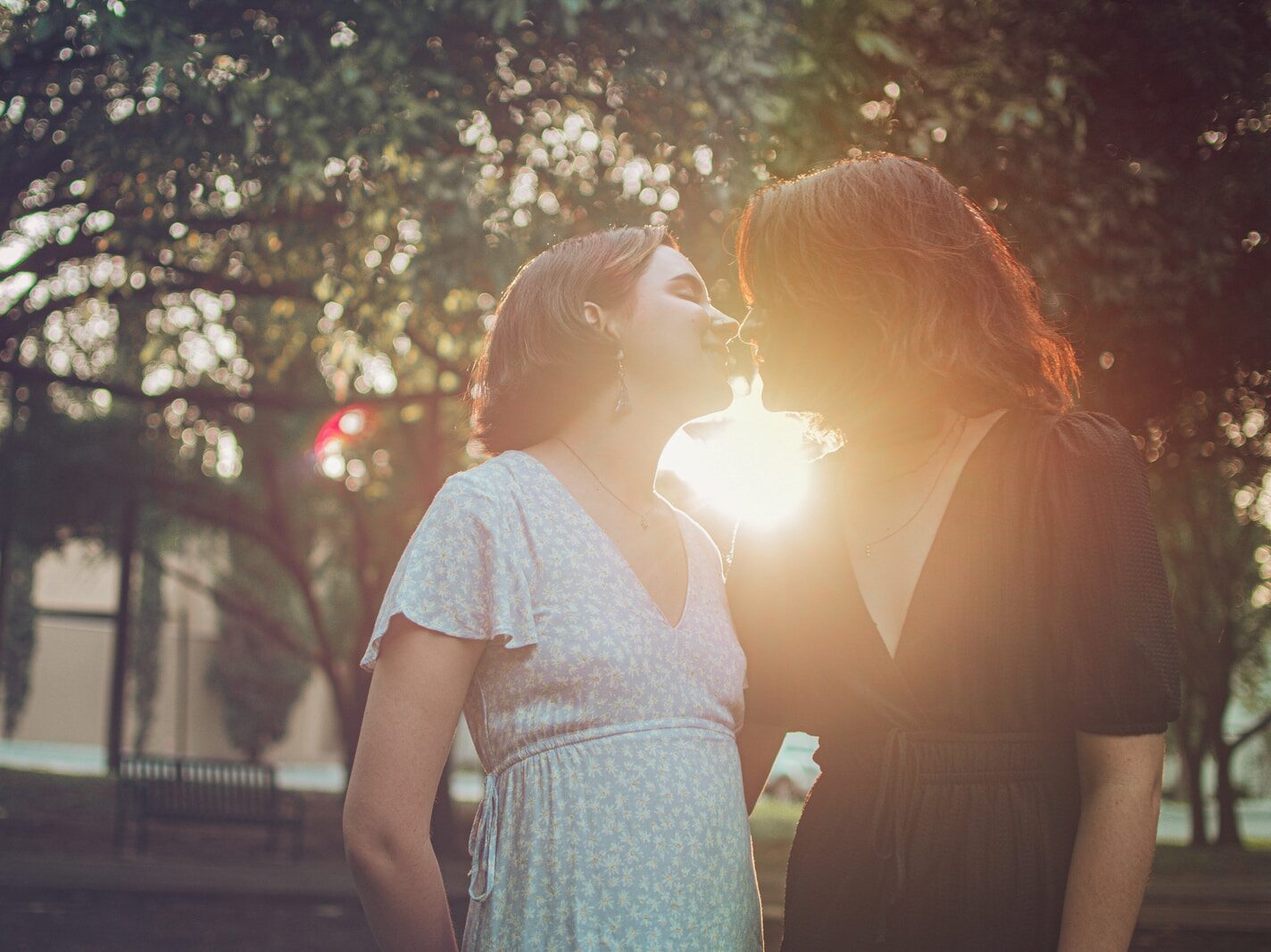 woman in white and blue floral dress standing near green trees during daytime