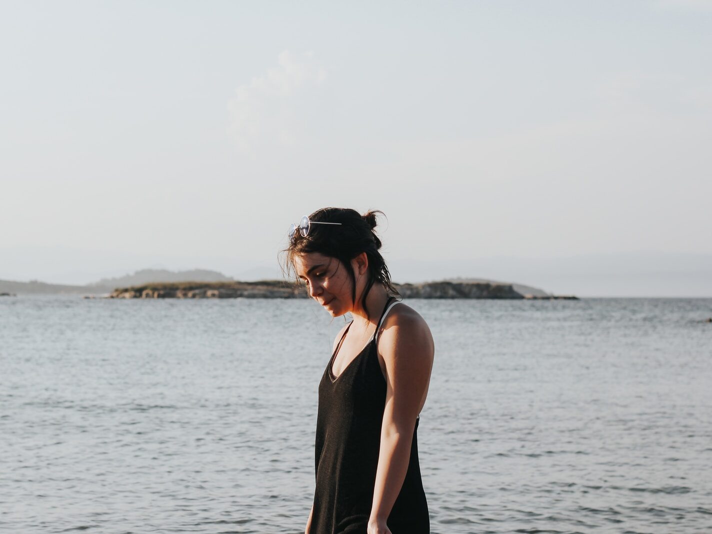 woman wearing black spaghetti strap dress beside beach