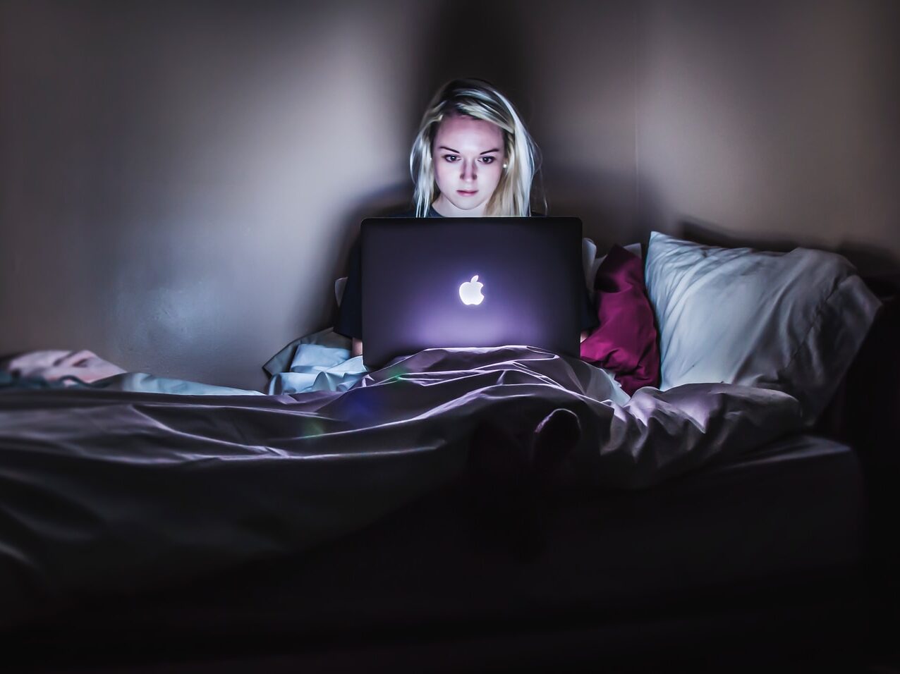 - ČasProŽeny.cz woman sitting on bed with MacBook on lap